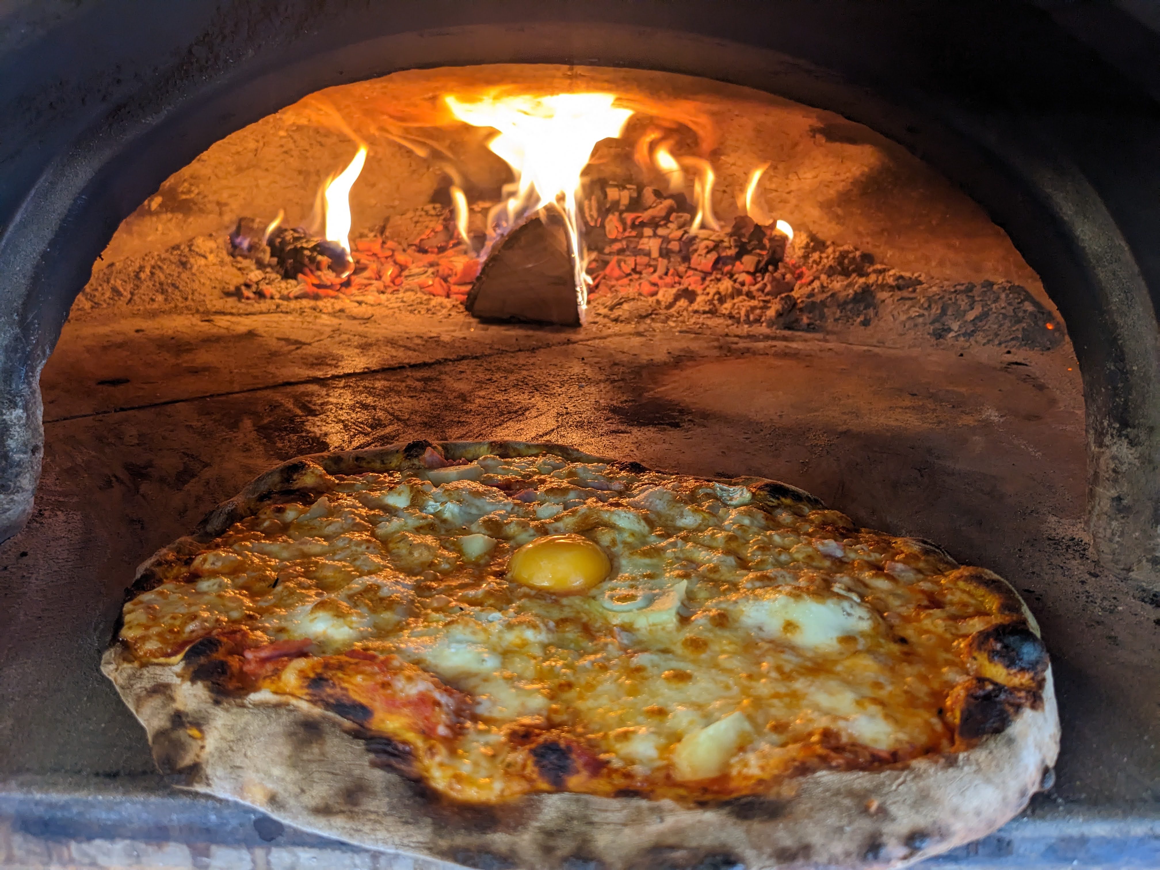 Pizza artisanale cuisant au feu de bois